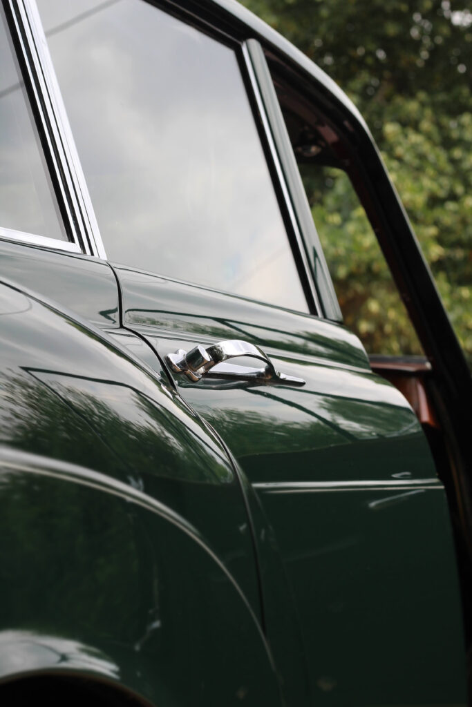 Side view of door details on an emerald green rolls royce silver cloud