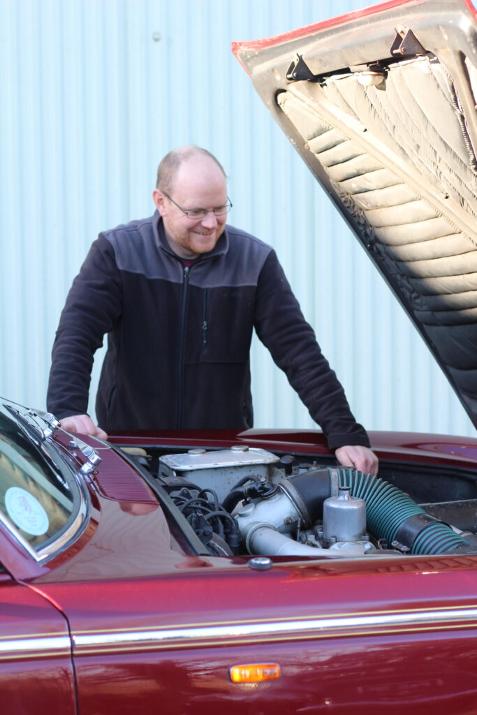 Matthew Tremayne of Harvey Wash Ltd standing over a Bentley engine bay