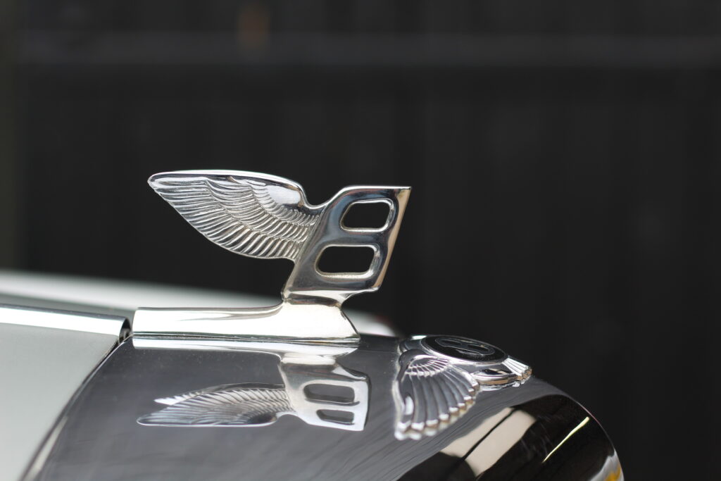 Bentley bonnet mascot in chrome, against a black background