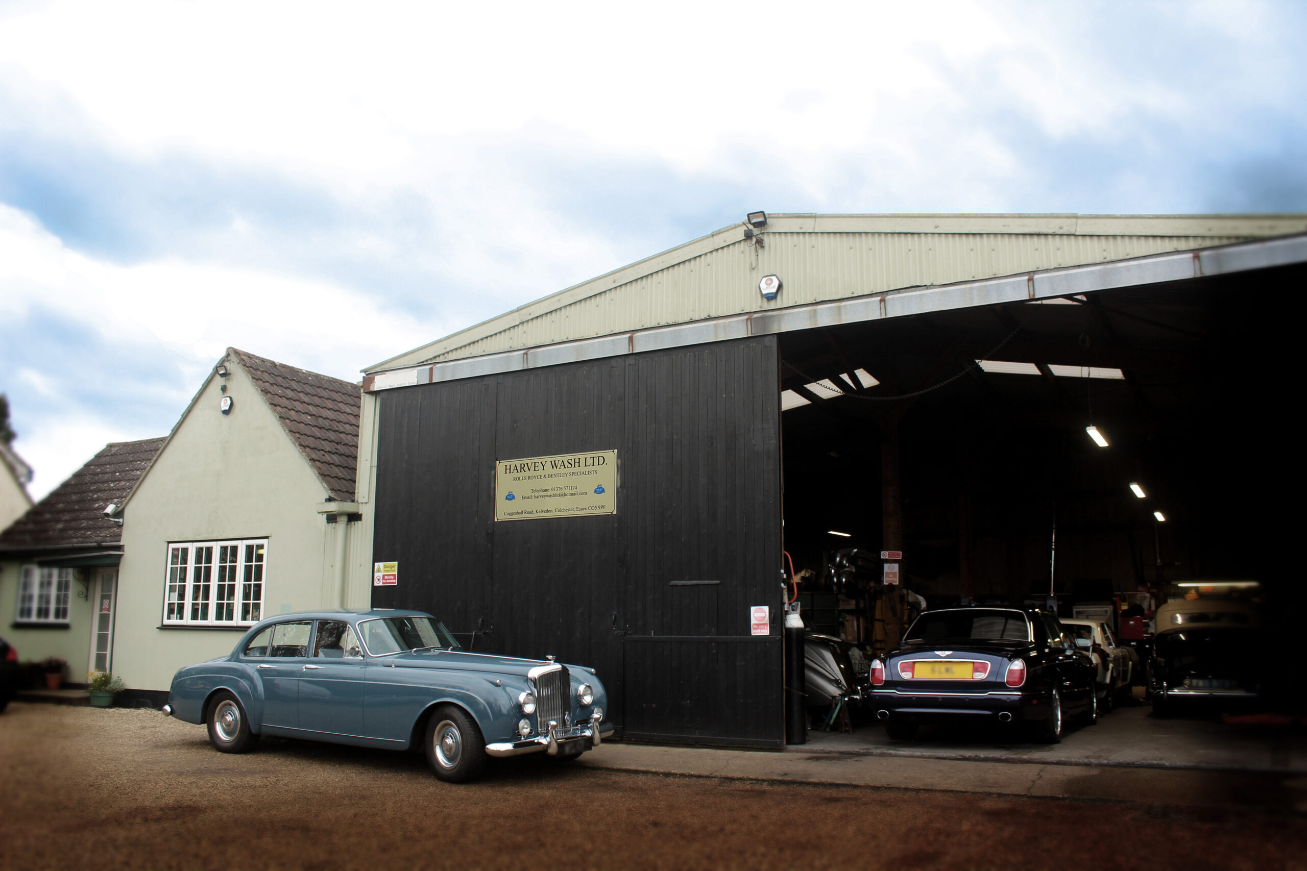 Harvey Wash Ltd workshop with powder blue Bentley S series parked outside. 