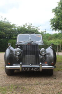 Rolls royce silver dawn rally car, front view. Car is silver/grey with rally stickers on the side