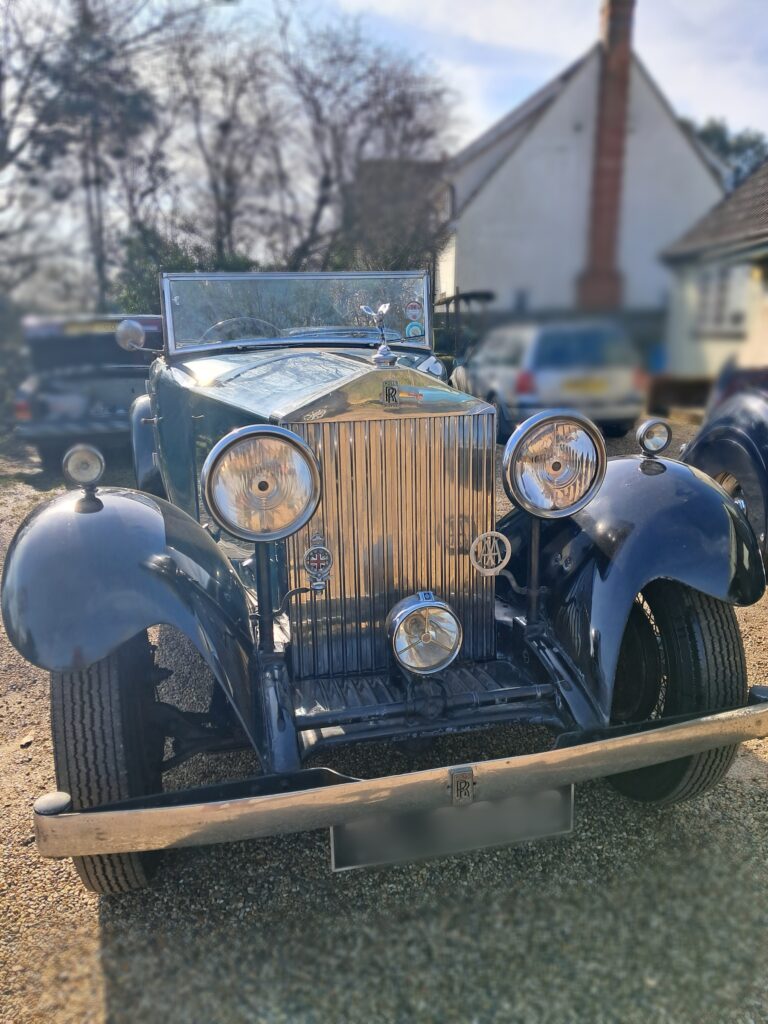 Front view of teal coloured rolls royce 20/25 with large grill and lights