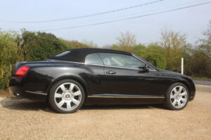 Bentley GT in black with roof up, drivers side view