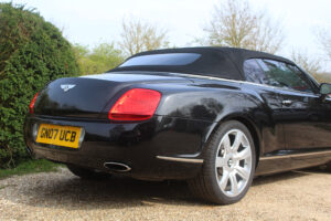 three quarters rear view of black Bentley GTC