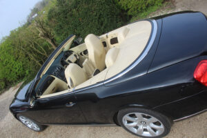 Black Bentley GTC top view with roof down and magnolia interior