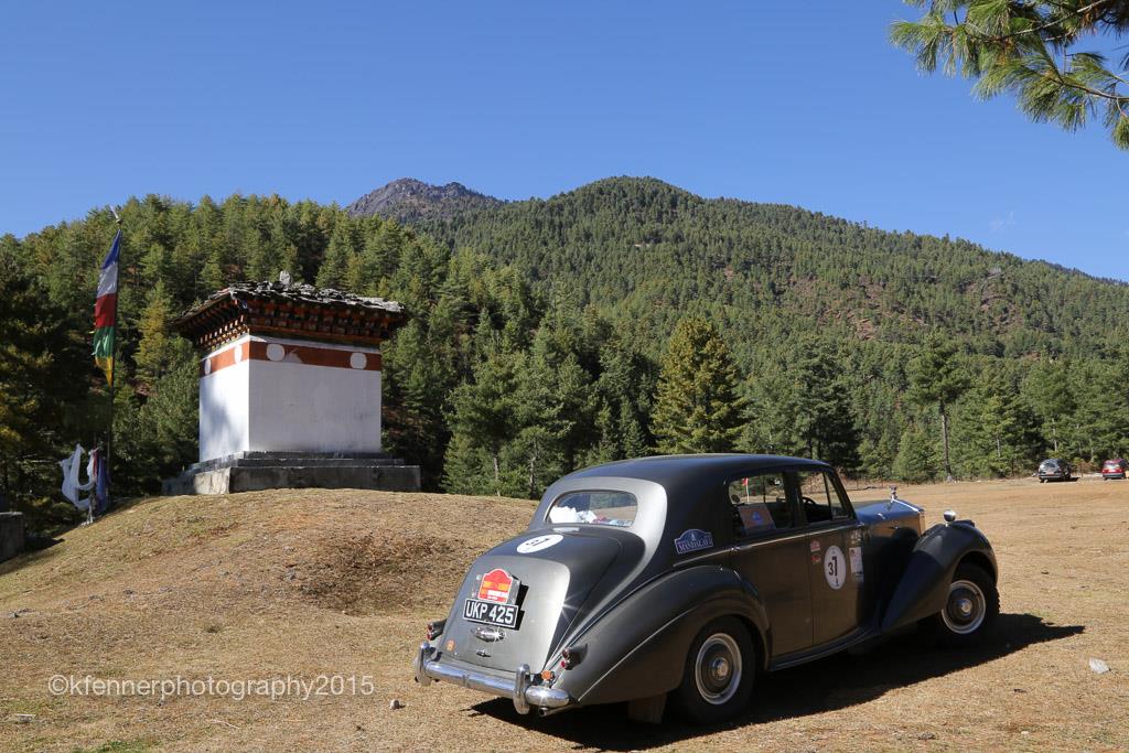 Rolls Royce Silver dawn rally car in grey in foregroud with Burma scenery and tower in background